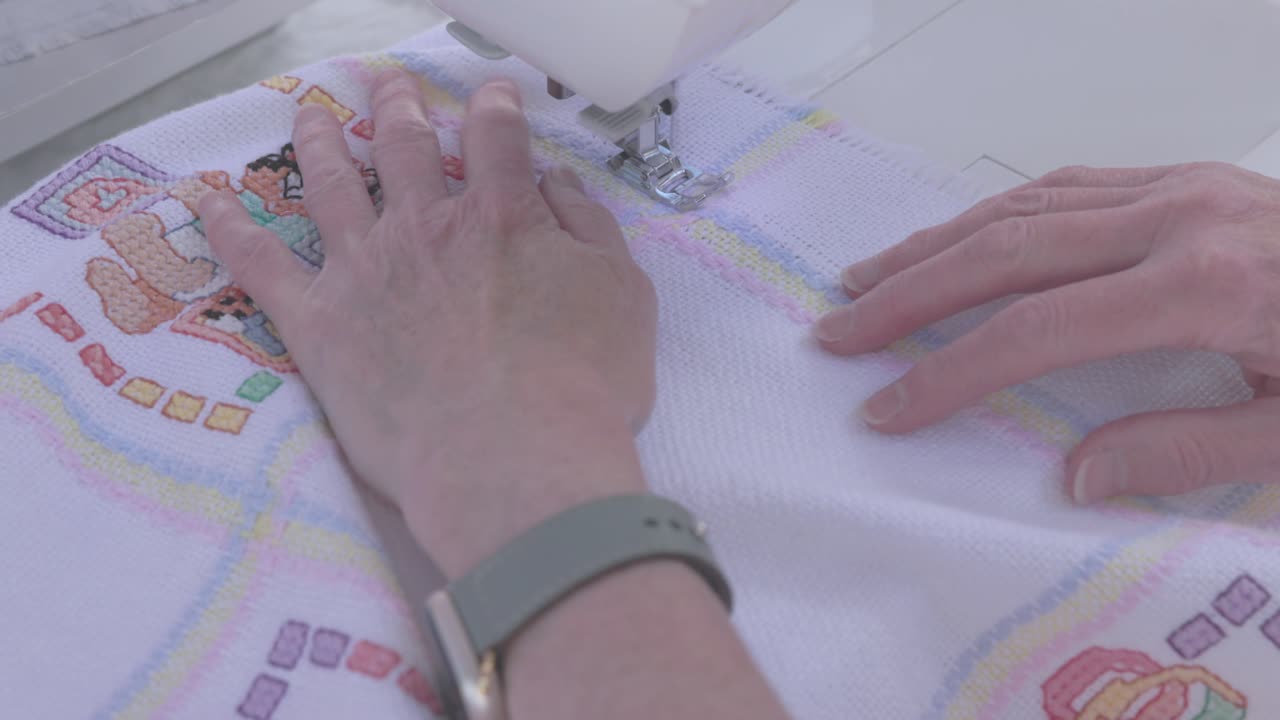 sewing machine stitching a border on a baby blanket ready to sell
