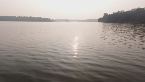 calm evening boat safari on kabini river, peaceful water reflections at sunset