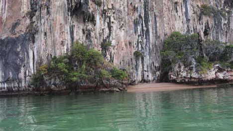 calm water gently laps against a rugged cliff