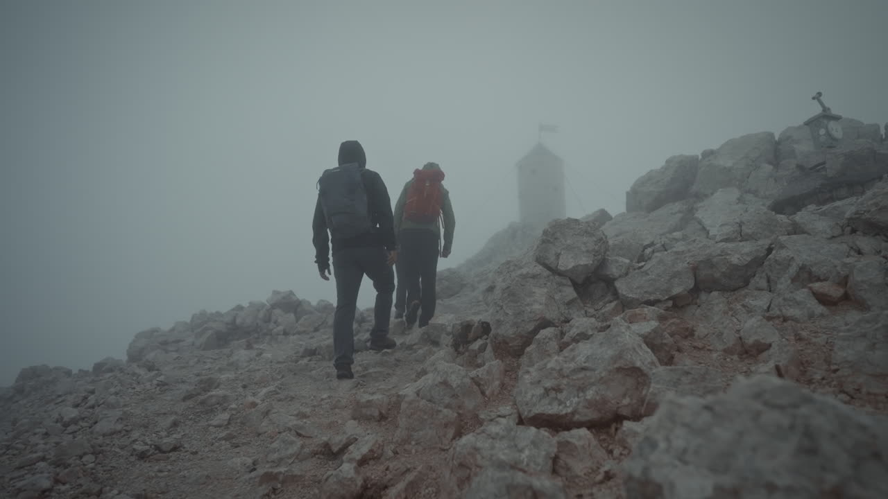los excursionistas están subiendo a la cima de la montaña triglav para llegar a la torre aljaž