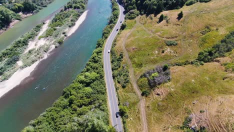 el video aéreo panorámico ofrece una vista superior de un río azul sereno con una carretera que corre a lo largo de él