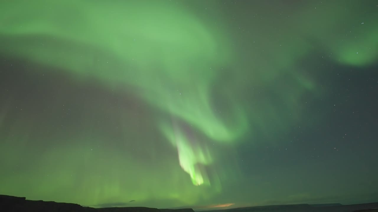 las fascinantes luces del norte bailan sobre un fiordo tranquilo en una oscura noche de invierno.