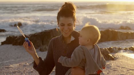 mother and baby boy playing with bubble wand 4k