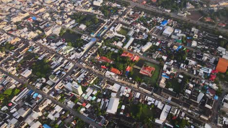 aerial: drone shot of a buddhist temple surrounded by densely populated city of korat, thailand