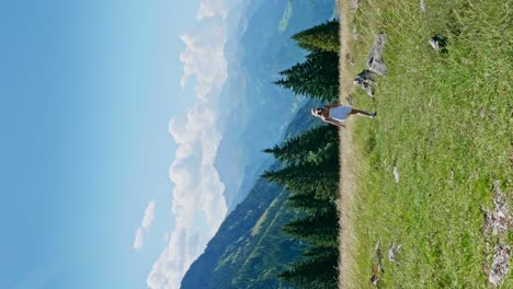 vertical rear view of girl in white skirt walking on pasture in mountains of austria during summer