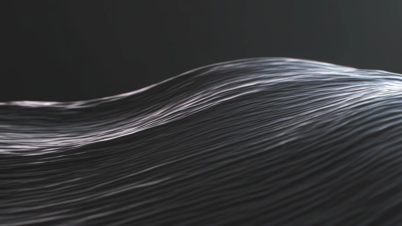 Forskydende masse af parallelle fibre bevæger sig mod højre i studiet, belyst af et højdepunkt, viser perlemorsglimt