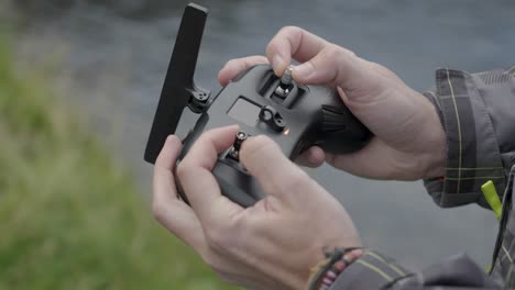 professional drone operator flying the drone outdoors, using the remote controler carefully