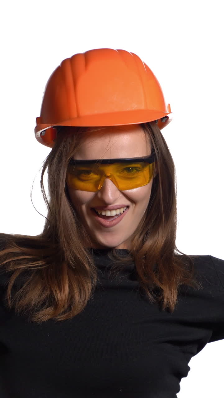 Worker contractor woman. Young woman showing her muscularity. Positive human emotions. Isolated on white background. Vertical video