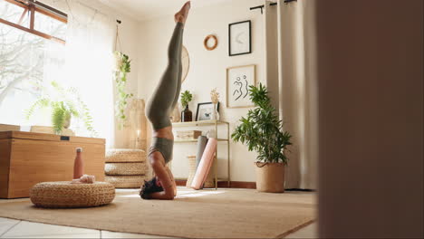 mujer practicando yoga de pie en la cabeza