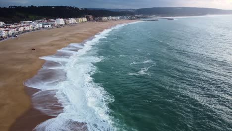 Vista-Aérea-De-Las-Olas-De-La-Playa-De-Nazare-En-La-Costa-Del-Océano-Atlántico-En-Portugal