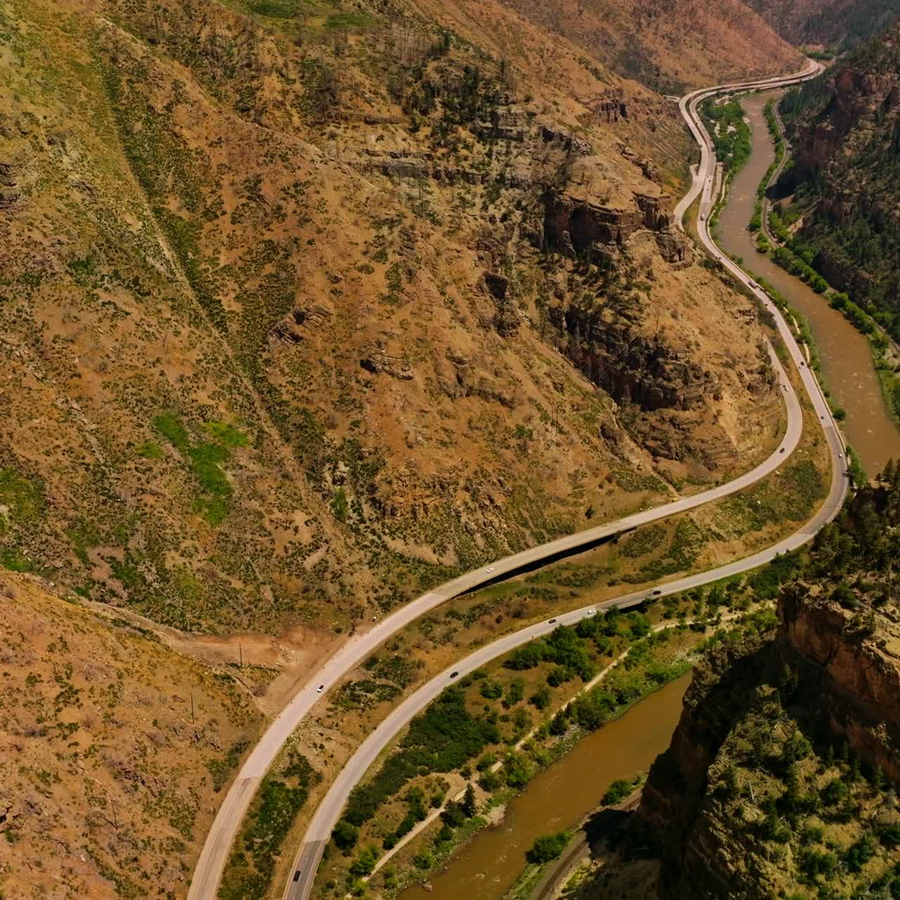 Colinas rocosas de montañas increíbles en Colorado, EE. UU. Río que fluye al pie de la montaña y carreteras que pasan a lo largo del río desde la vista aérea