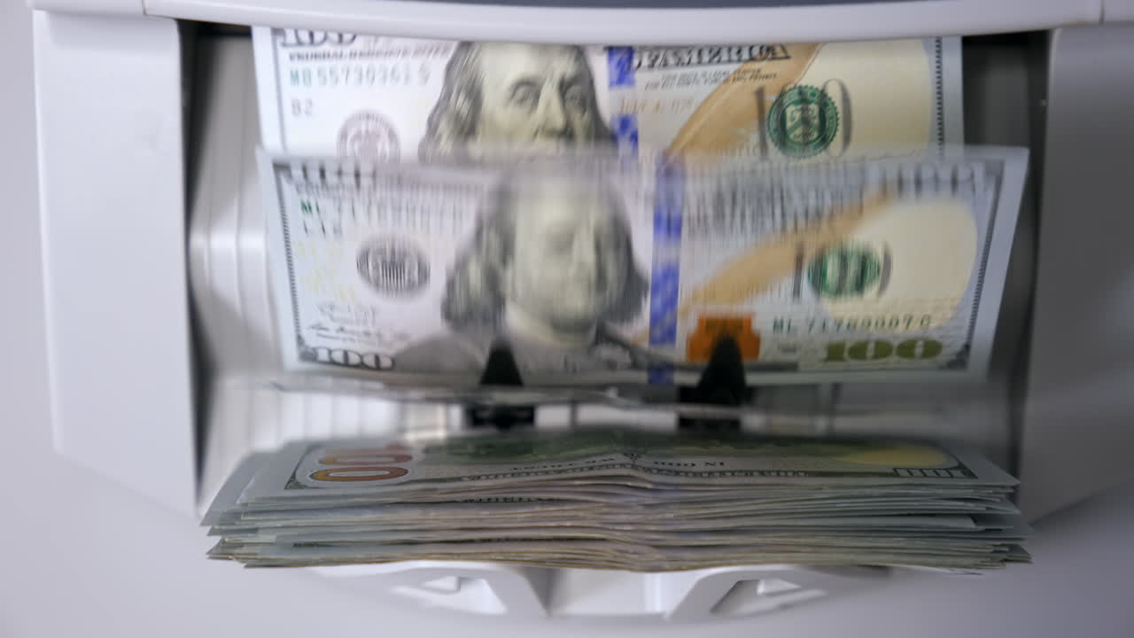 Money counting equipment for paper money calculation. Automatic mechanism for bank financial operations. Currency exchange of one hundred usd. Closeup currency counting machine counting dollar bills