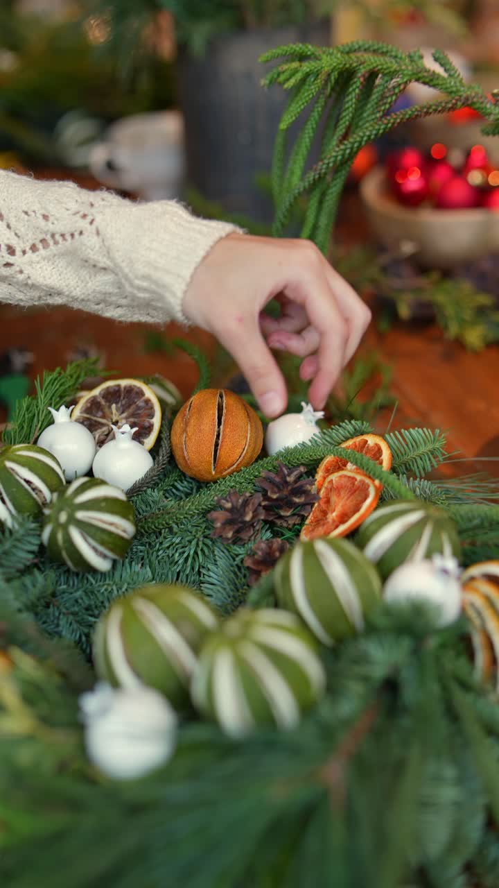 creando una corona navideña festiva con cítricos secos y granadas
