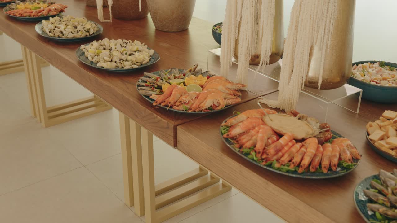 새우, 조개, 게가 테이블에 놓여 있는 해산물 뷔페 플레이트 디스플레이