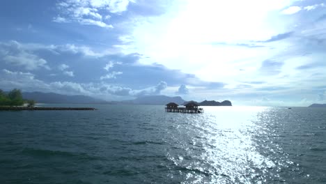 Vuelo-Rápido-Sobre-Aguas-Azul-Esmeralda-A-Través-De-Una-Casa-Sobre-Pilotes-En-La-Playa-De-Tanjung-Rhu,-Langkawi,-Malasia