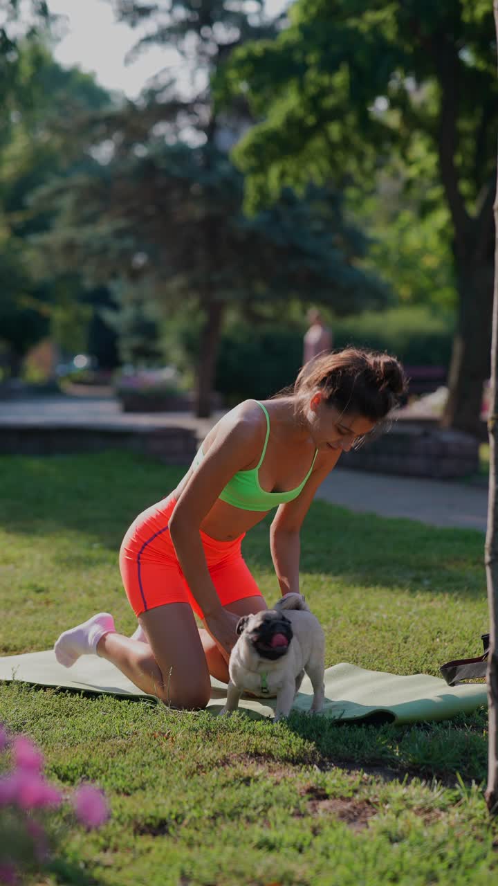 mujer haciendo yoga con su pug en el parque