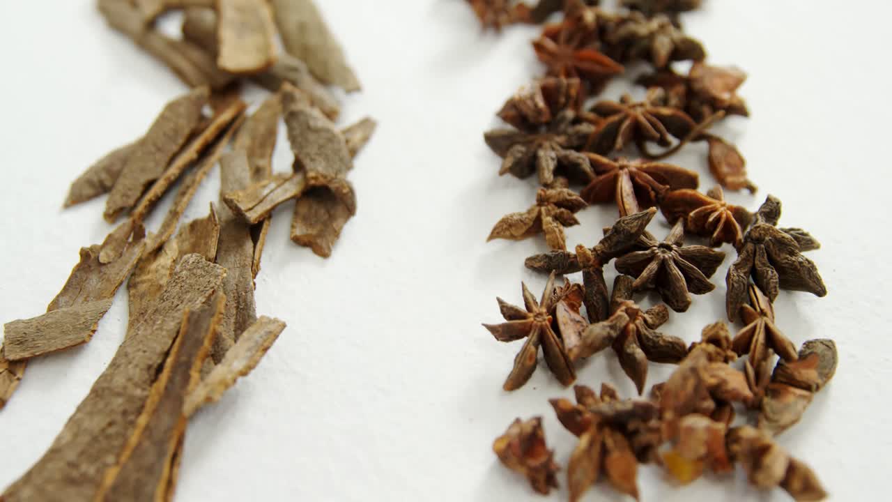 anís estrellado y palitos de canela sobre fondo blanco 4k