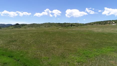 sliding drone pan of an ideal foothills landscape ending with a descent behind a rusty gate