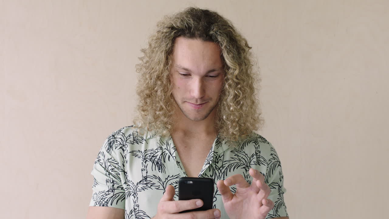 ritratto di un giovane attraente che sorride usando uno smartphone navigando sui social media