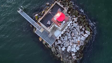 a top down, aerial view of the huntington harbor lighthouse on long island, ny at sunset