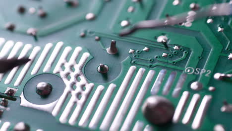 Close-up-of-a-technician's-soldering-tools-while-repairing-some-parts-of-a-circuit-board-panel