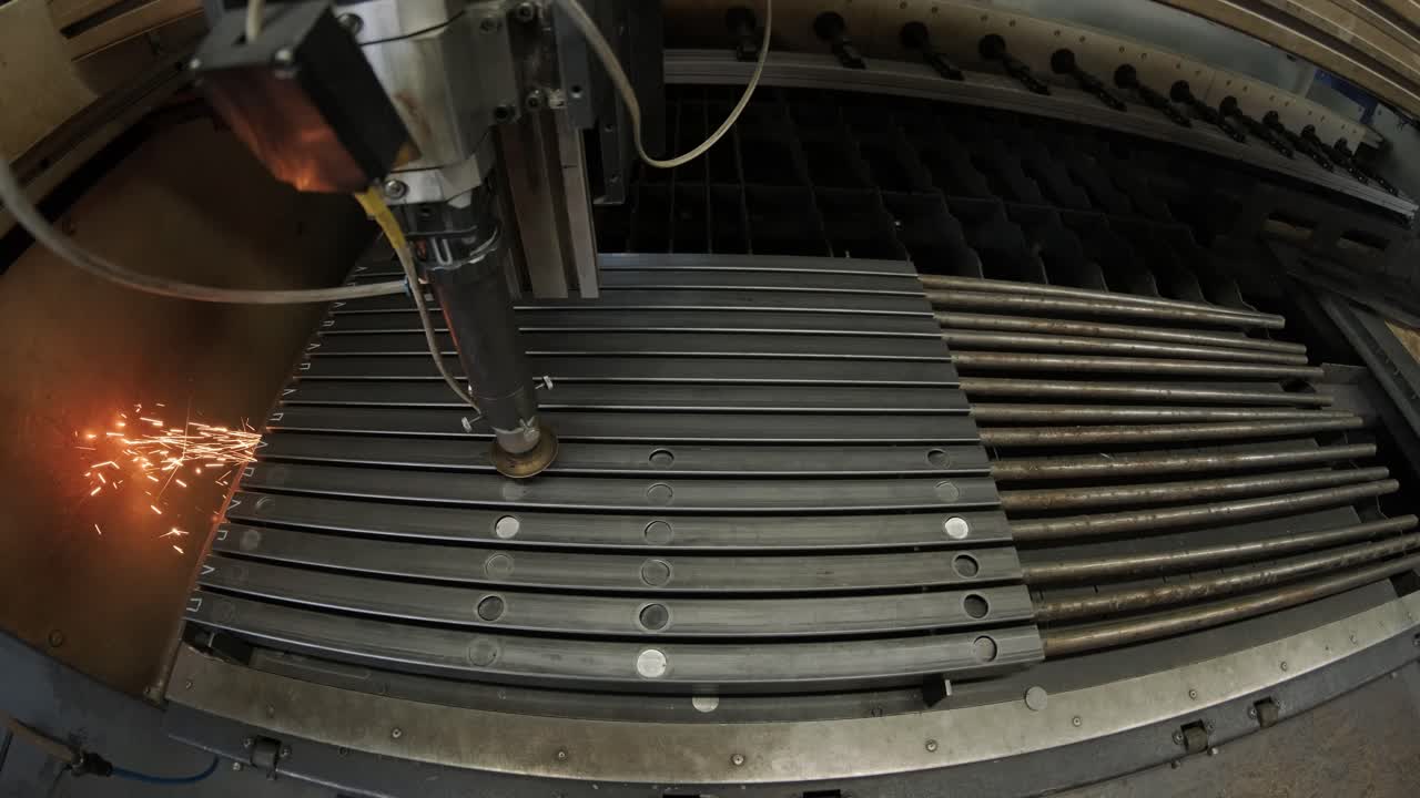 современная промышленная лазерная машина с cnc, технология резки металла. лазерная резка стальных труб на современном заводе. лазер разрезает отверстия в трубе.