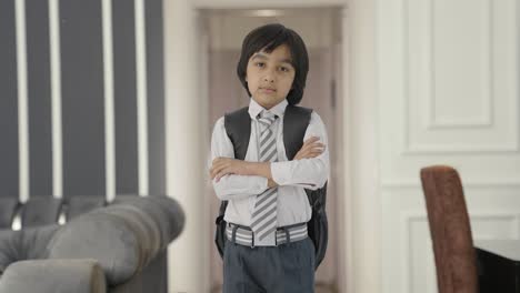 Confident-Indian-school-boy-standing-crossed-hands