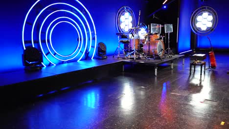 drum set on stage with lighting in the background ready for concert.