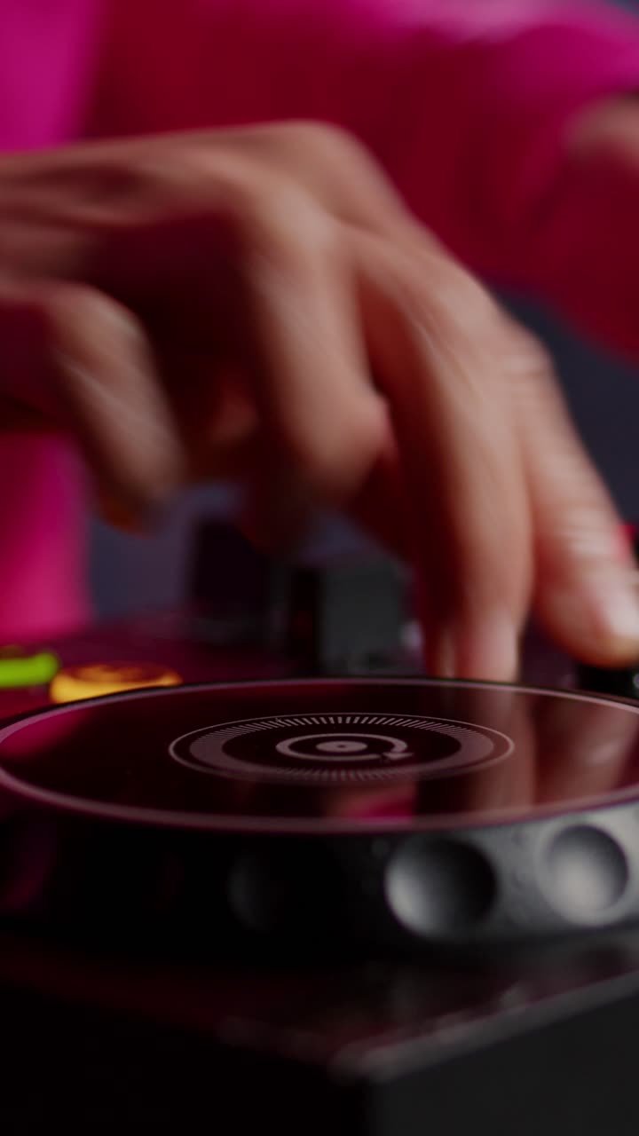 Video verticale: musicista in piedi alla console da DJ che mixa suoni