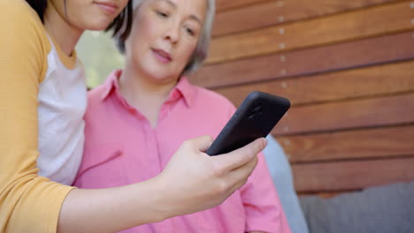 showing smartphone to senior asian woman, young asian woman helping with technology at home