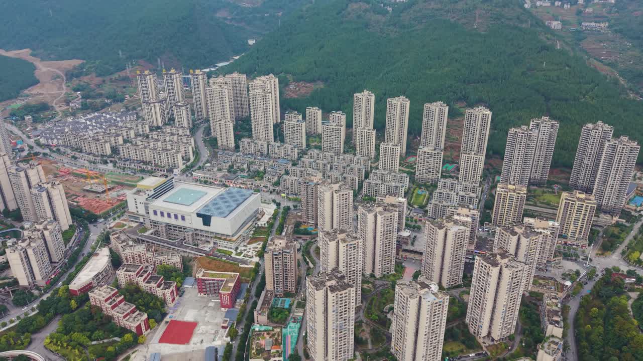 Vista aérea do horizonte moderno de Wuxi, com arranha-céus densos em contraste com um cenário montanhoso exuberante, crescimento urbano e contraste panorâmico ideais para projetos de viagens, arquitetura e paisagens urbanas. China, UHD