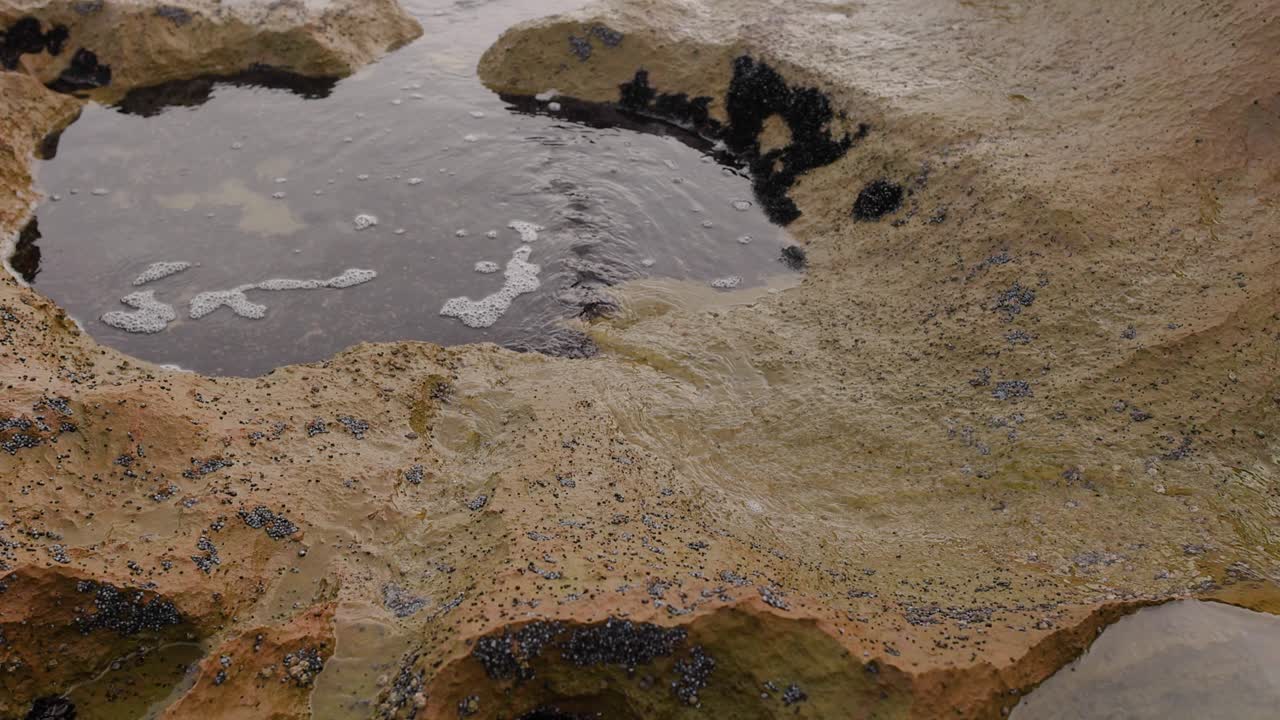 la marea fluye sobre rockpool en la playa