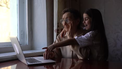 Great-Grandmother-and-granddaughter-wave-to-family-on-computer