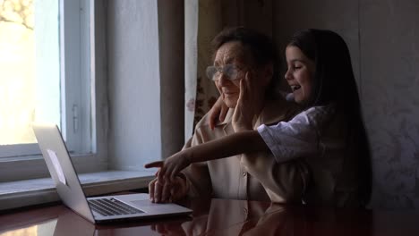 la bisabuela y la nieta saludan a la familia en la computadora