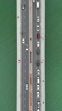 vertical aerial view of the dongshuimen bridge in chongqing, china, with traffic flowing across multiple lanes. a snapshot of urban connectivity, showcasing infrastructure and the dynamic city life.
