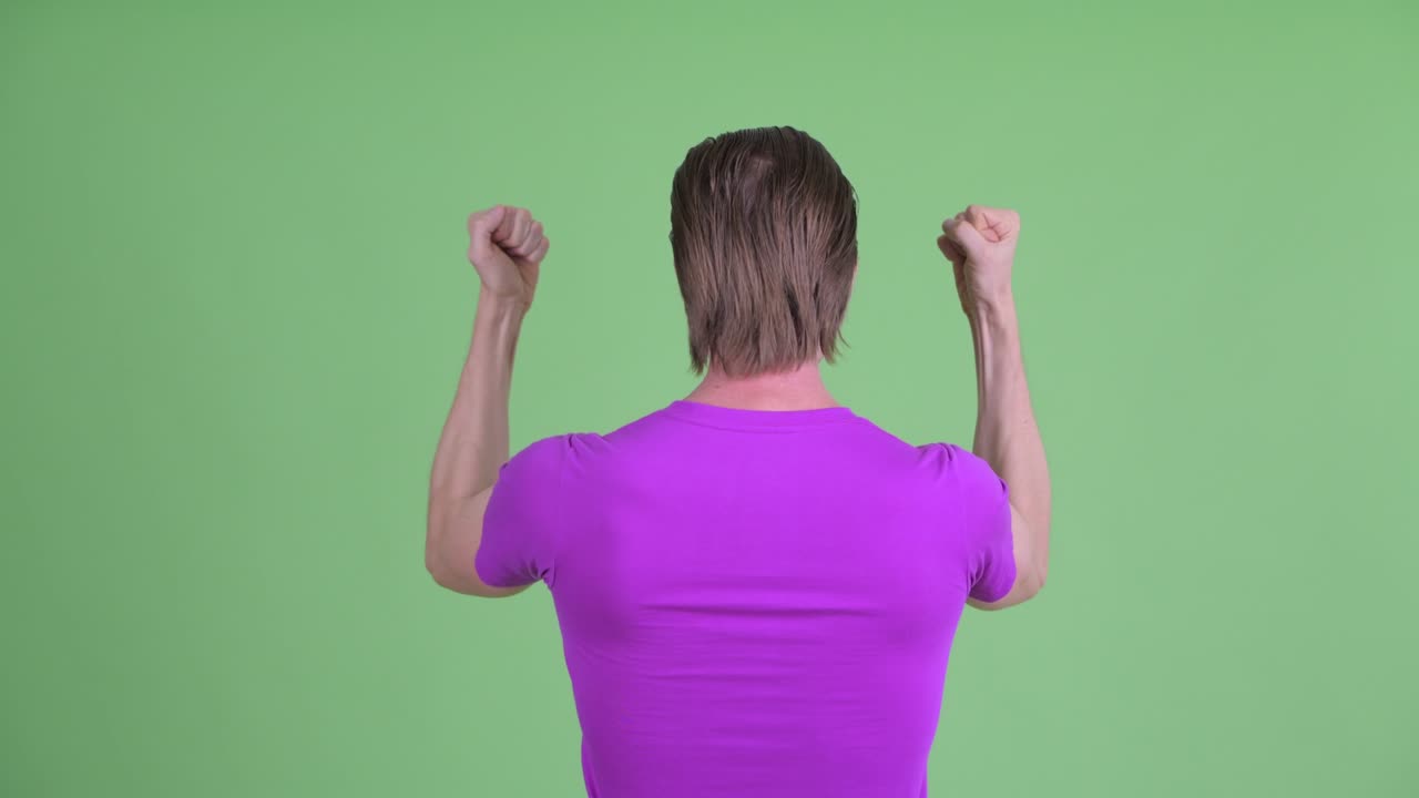 녹색 배경에 팔을 들어 올린 젊은 남자의 스튜디오