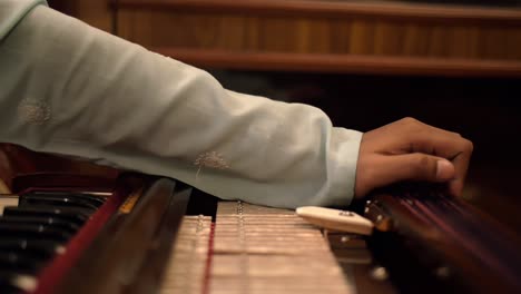 Panning-Shot-of-a-Man-Playing-the-Harmonium