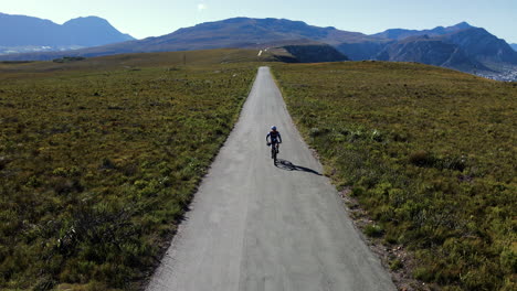 Aerial-view-of-male-cyclist-on-MTB-bike-cycling-on-mountain-road,-Hermanus