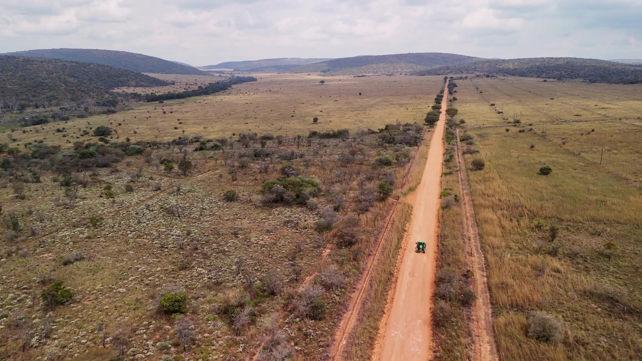 Ripresa con drone di un trattore solitario che attraversa le pianure rurali sudafricane.