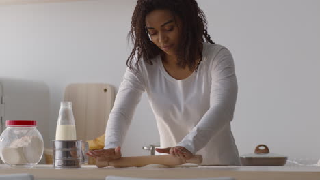 Woman Rolling Dough in a Kitchen