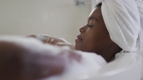 Portrait-of-african-american-attractive-woman-relaxing-in-foam-bath-in-bathroom