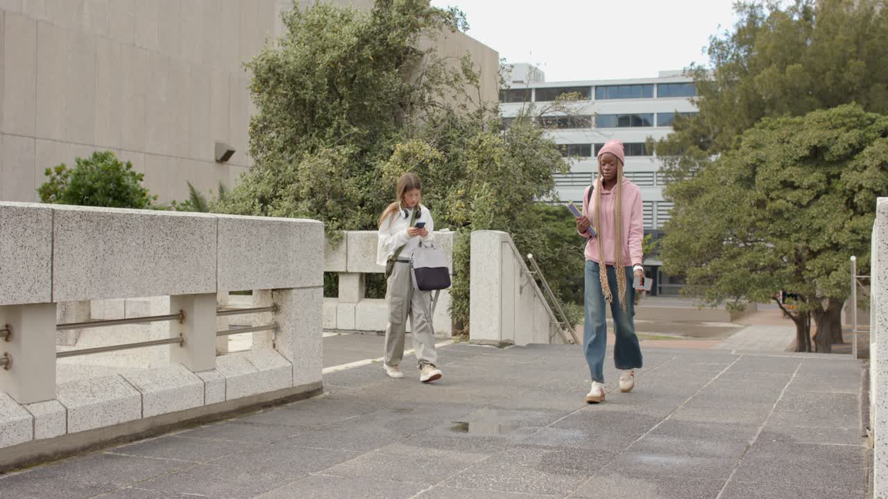 Mujeres diversas caminando por la plaza, usando sus smartphones para revisar mensajes mientras sostienen una taza de viaje.