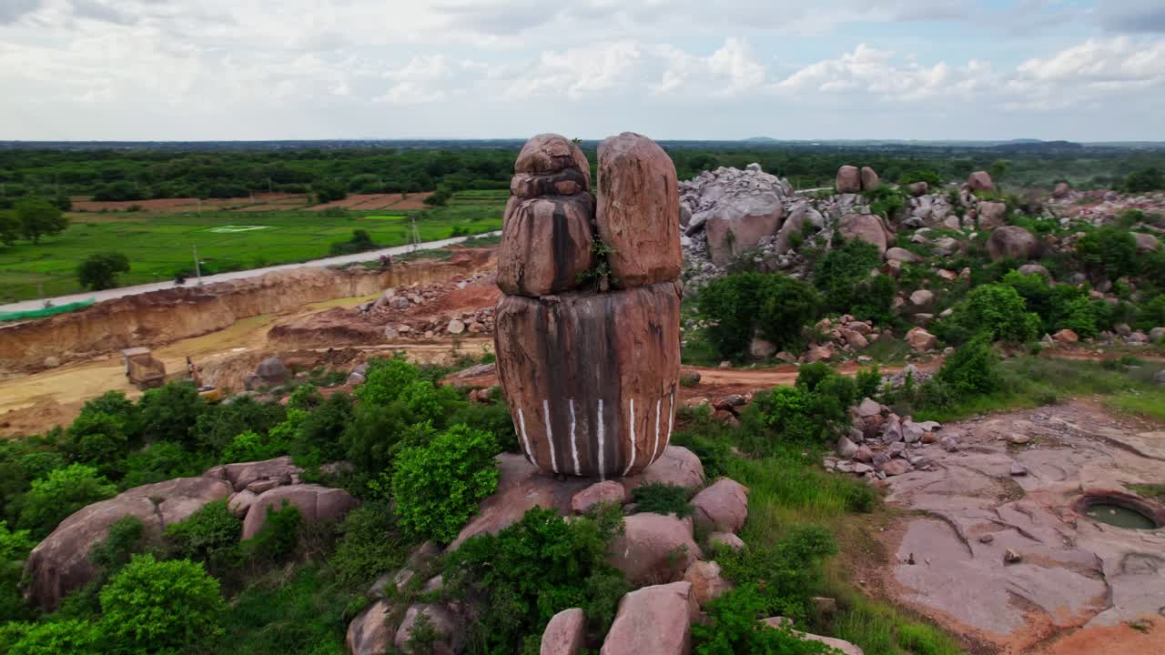 Granite hill, stone mining with sand mining and rainy clouds at telangana, india. day time, circle shot, drone shot, 4k.