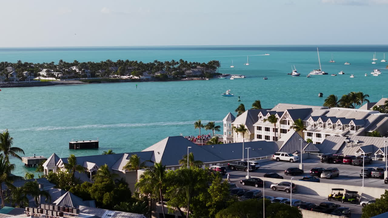 Aerial view of the oastline of Key West with boats driving by, sunset in Florida