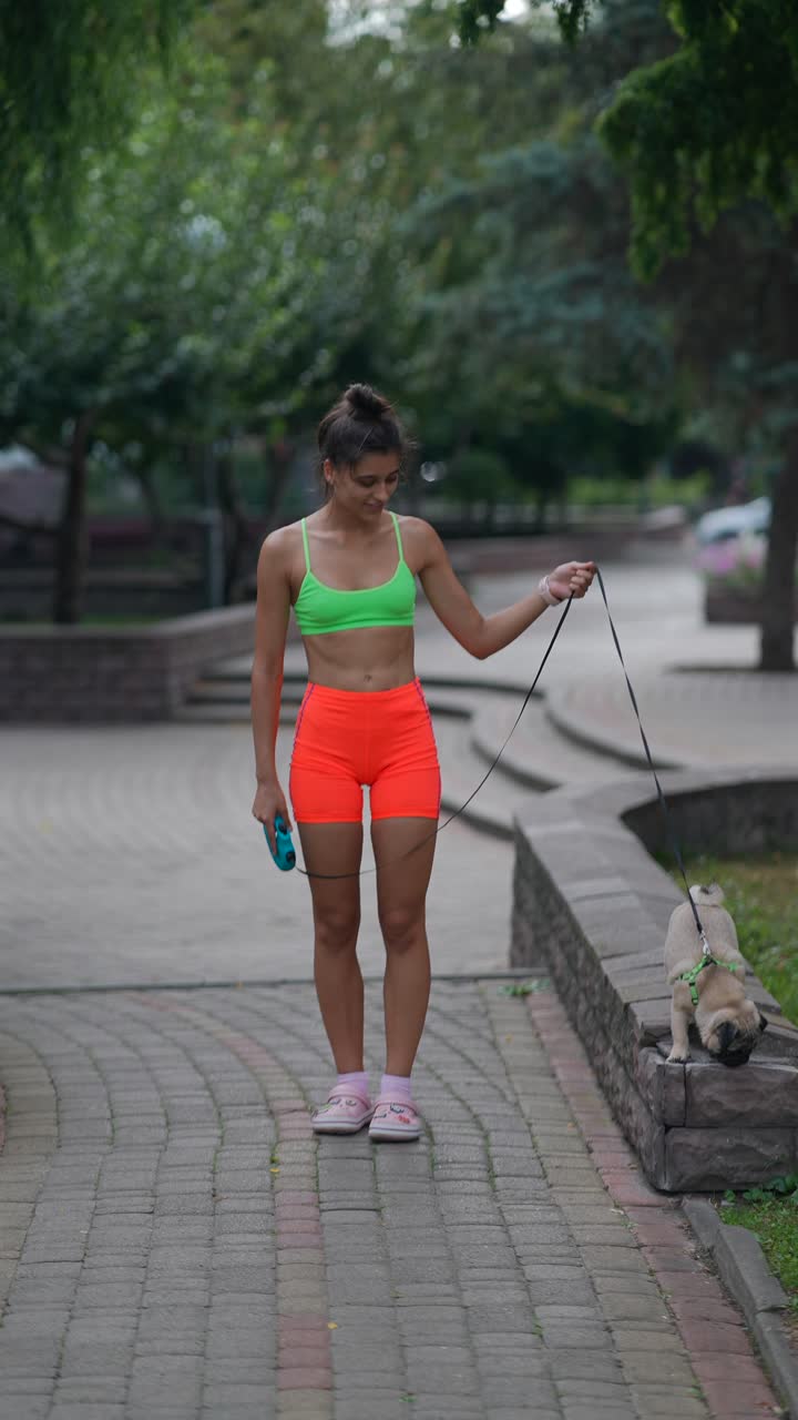 mujer paseando al perro en el parque