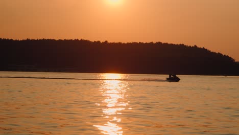 Motorboot-Rast-Bei-Sonnenuntergang-Den-See-Hinunter