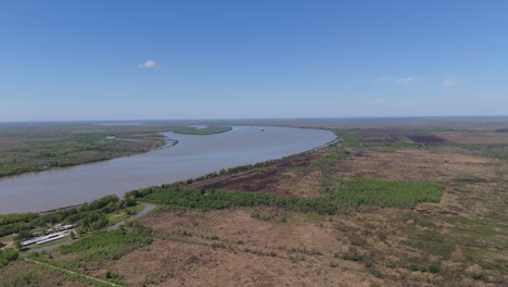 aerial perspective of the parana guazu river winding through lush greenery and expansive wetlands under a clear blue sky, showcasing the natural beauty and vastness of the region's ecosystem