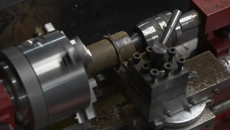 lathe machine shaping a rotating cylindrical workpiece at wood factory. slow motion, static shot