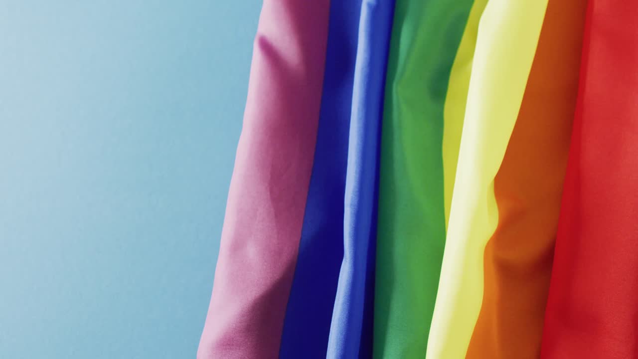 복사 공간과 함께 파란색 배경 위에 무지개 직물의 비디오