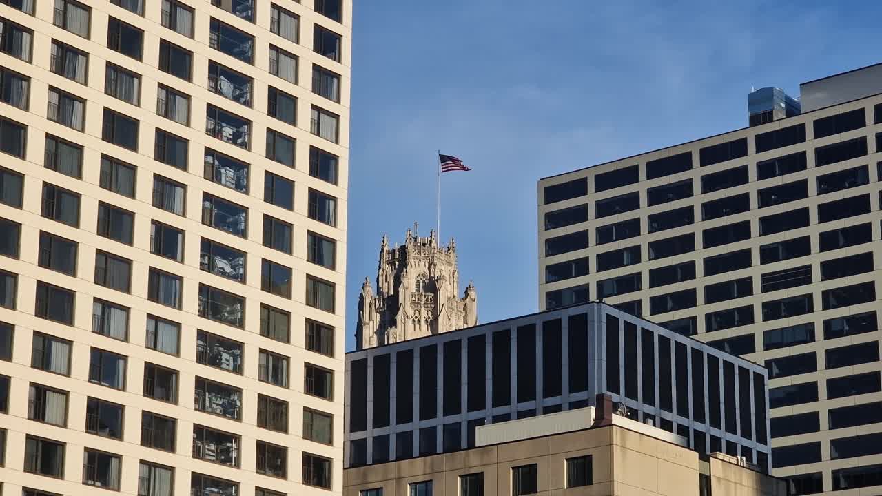 Bandiera americana che sventola in cima al palazzo nel centro di Chicago, Illinois, USA in una giornata di sole